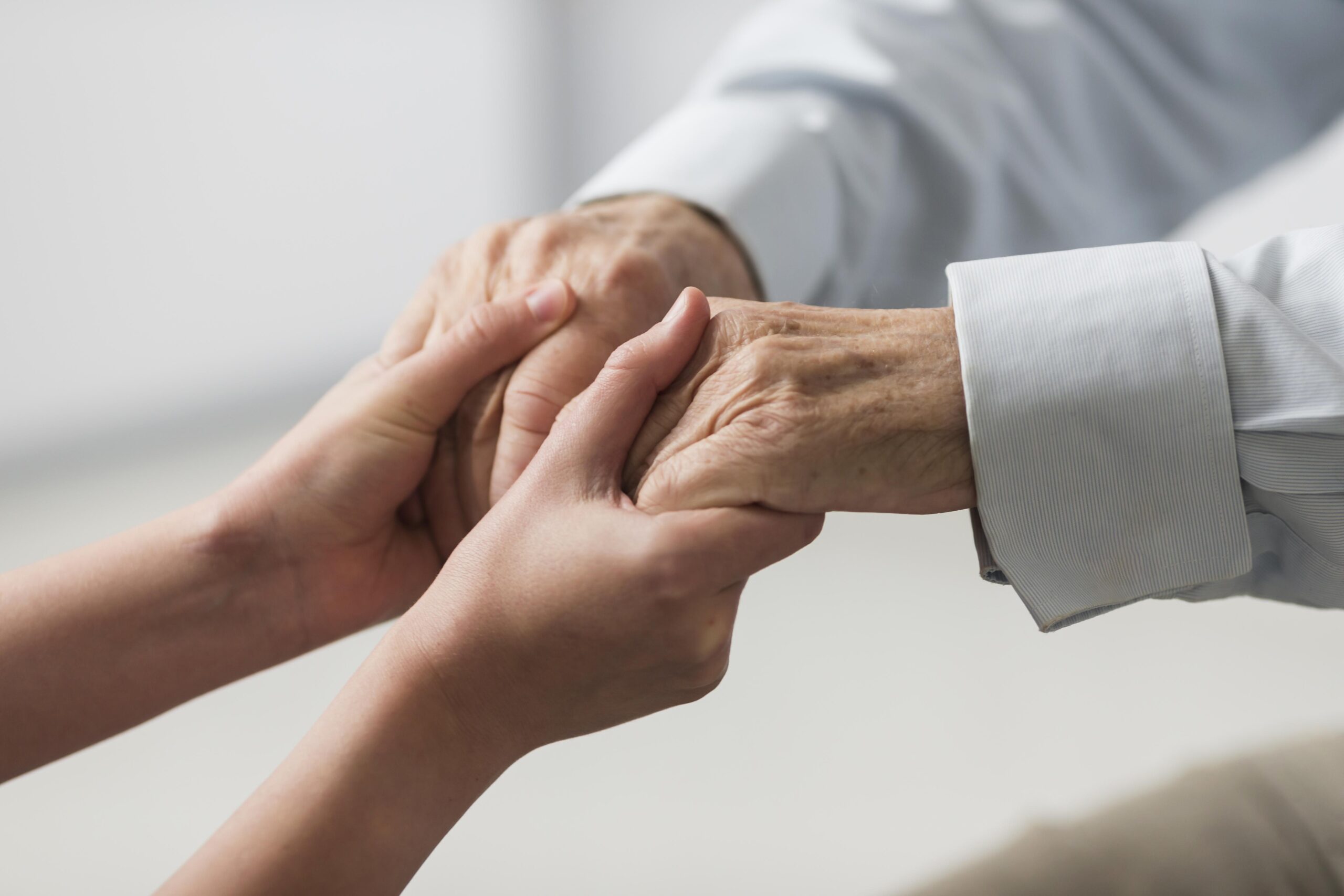 nurse holding senior man s hands sympathy scaled Integra Psicologia São Paulo